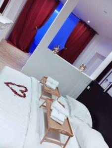 um quarto com uma cama branca e cortinas vermelhas em NG SuiteHome - Lille l Tourcoing Winoc - Balnéo - Sauna - Netflix - Wifi em Tourcoing
