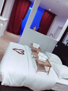 um quarto com uma grande cama branca e um espelho em NG SuiteHome - Lille l Tourcoing Winoc - Balnéo - Sauna - Netflix - Wifi em Tourcoing
