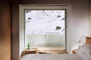 a bedroom with a view of a snow covered mountain at House of Architects in Vals