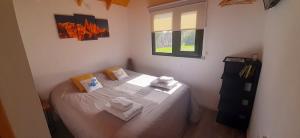 a small bedroom with a bed with towels on it at Patagonia Tiny House in El Chalten