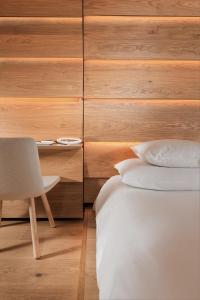 1 dormitorio con 1 cama, 1 mesa y 1 silla en House of Architects, en Vals