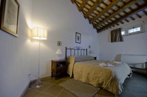 a bedroom with a bed and a table and a lamp at Erice Pietre Antiche - Classic Suites in Erice