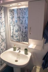 ein Bad mit einem Waschbecken und einem Spiegel in der Unterkunft Blue Diamond in Chrani