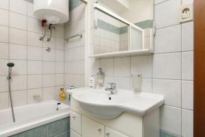 a white bathroom with a sink and a bath tub at Apartman Z in Split +19 photos