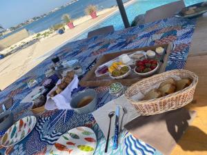a picnic table with food on the beach at Les pieds dans l’eau in Sète