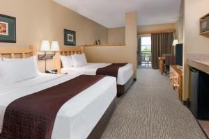 トラバースシティにあるグレート ウルフ ロッジ トラヴァース シティのベッド2台とバルコニーが備わるホテルルームです。