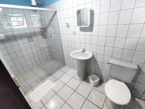 a bathroom with a toilet and a sink at Pousada Boiçucanga a 30m da praia in Boicucanga
