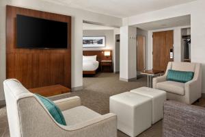 Delta Hotels by Marriott Minneapolis Northeast في مينيابوليس: غرفة معيشة مع أريكة وتلفزيون