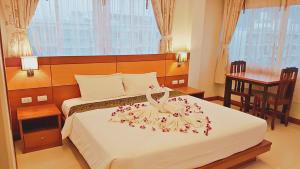a hotel room with a bed with a dress on it at Green Harbor Hotel & Service Apartment in Patong Beach