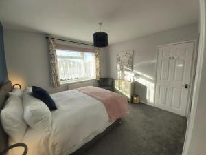 Totland的住宿－Corner Cottage，一间卧室设有一张大床和一个窗户。