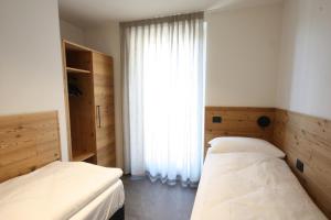 1 Schlafzimmer mit 2 Betten und einem großen Fenster in der Unterkunft Casa Montana in Commezzadura