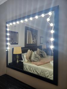 a mirror of a bedroom with a bed with lights at Suikerbosrant Sleep and go in Pretoria