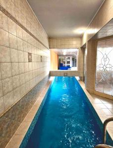 a pool in a hotel room with blue water at Villa Wellness in Budapest