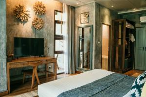 a bedroom with a bed and a flat screen tv at Sand in My Shoes Beach Loft in Thong Nai Pan Noi