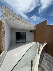 an external view of a building with a glass walkway at La casa de 3 suítes em Guriri - equipada para 8 pessoas in São Mateus