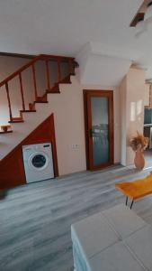 sala de estar con escalera y lavadora en Deniz Manzaralı Müstakil ev Aybalik, en Ayvalık