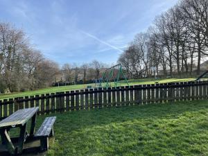 einen Park mit einer Bank und einem Spielplatz in der Unterkunft Globe Apartments in Glastonbury + 15 Fotos