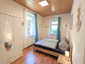 a bedroom with a bed and two windows at R1 - Urlaubsmagie - Bad Schandau fußläufig, Garten in Rathmannsdorf