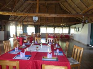a dining room with a table with red table cloth at Acaki Lodge in Kitgum