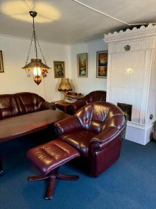 - un salon avec un canapé en cuir et une chaise dans l'établissement Lilla Röda Huset., à Sjötofta