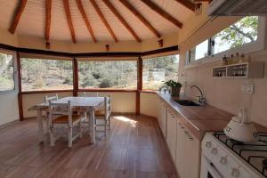 a kitchen with a table and chairs in a room at Cabaña a Arroyo Cristal in Tanti