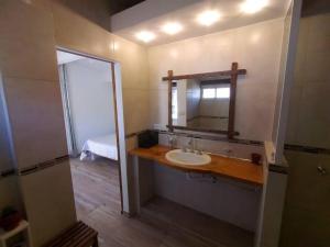 un baño con lavabo y espejo en Cabaña a Arroyo Cristal, en Tanti