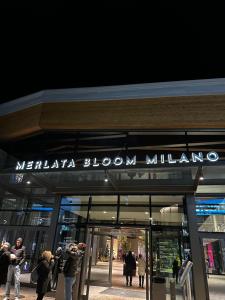 a group of people taking pictures outside of a store at Sweet Home in Milano smart district in Milan