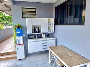a small kitchen with a table and a refrigerator at Studio #3 Rubi in Campos dos Goytacazes