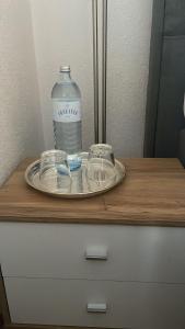 a bottle of water and two glasses on a table at Haus Karin Mallnitz in Mallnitz