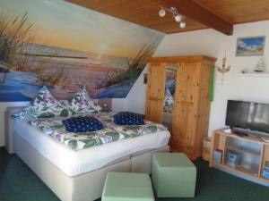 ドルヌムにあるFerienwohnung Rabensteinのベッドと壁に絵が飾られた寝室