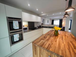 a kitchen with a wooden table with yellow flowers on it at Chandlers Ford Home in Southampton