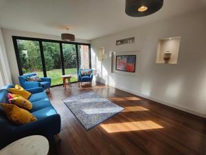 a living room with blue couches and a large window at Chandlers Ford Home in Southampton