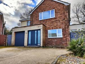a brick house with a blue garage at Chandlers Ford Home in Southampton