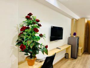 ein Zimmer mit einer Pflanze mit roten Rosen in der Unterkunft The Grand Anukampa Inn Pink City in Jaipur