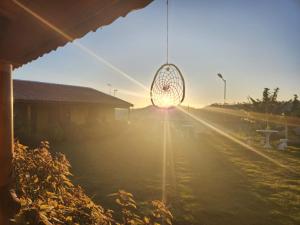 a view of the sunset from a window with a net at Pousada do Sossego in Extrema