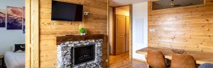 ein Wohnzimmer mit einem Kamin und einem TV in der Unterkunft Appartement de 2 chambres avec piscine partagee et balcon amenage a Les Orres in Les Orres