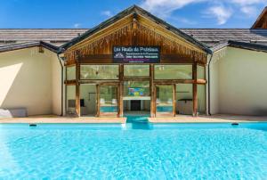 a building with a swimming pool in front of it at Appartement de 2 chambres avec piscine partagee et balcon amenage a Les Orres in Les Orres