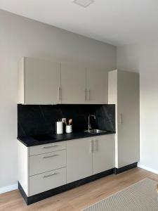 a kitchen with white cabinets and a black counter top at Top Balea in Pontevedra