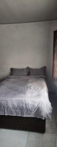 a bedroom with a bed with white sheets and pillows at Salama Guest House in Lusaka