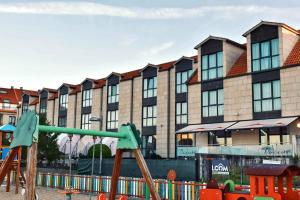 a playground in front of a large building at Hotel Alda Carril in Vilagarcia de Arousa