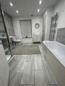 y baño con bañera, aseo y lavamanos. en Modern, spacious and Central Location, en Aberdare