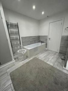 y baño con bañera y alfombra. en Modern, spacious and Central Location, en Aberdare