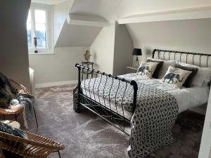 a bedroom with a black bed with pillows at Le Bourg in Asnières-en-Bessin