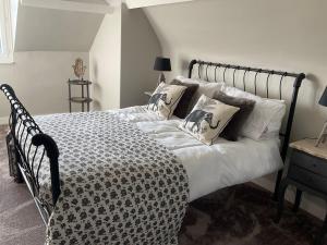 a bedroom with a black and white bed with pillows at Le Bourg in Asnières-en-Bessin