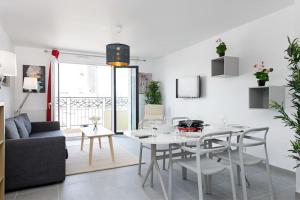 Una sala de estar con una mesa y sillas blancas. en Magnifique appartement à proximité de Paris, en Saint-Ouen 16 fotos más
