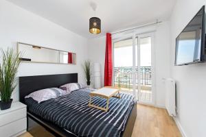 Un dormitorio con una cama con una mesa encima. en Magnifique appartement à proximité de Paris, en Saint-Ouen