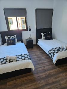 two beds in a room with wooden floors at Hotel Masai Mara Resort Gran Canaria in San Bartolomé