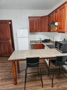 a kitchen with a table with chairs and a counter top at Hotel Masai Mara Resort Gran Canaria in San Bartolomé de Tirajana