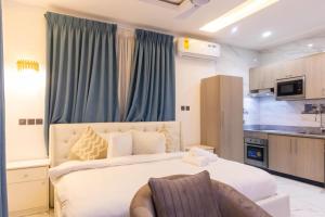Un dormitorio con una cama grande y una cocina. en Premier Studio Apartment, East Airport, en Accra