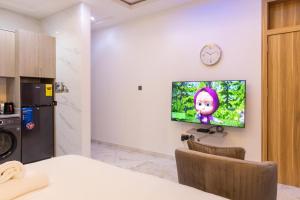 Una sala de estar con un televisor en la pared. en Premier Studio Apartment, East Airport, en Accra